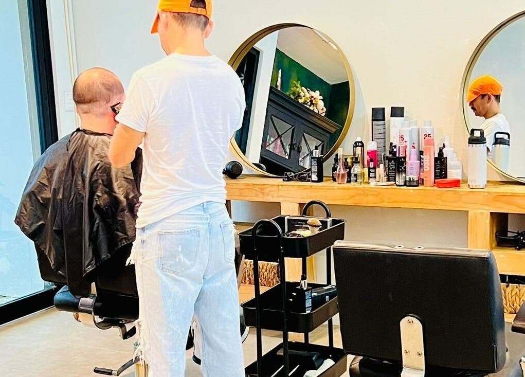 Un estilista corta el pelo de un cliente en Rivalbo, Grecia, Provincia De Alajuela, CR.