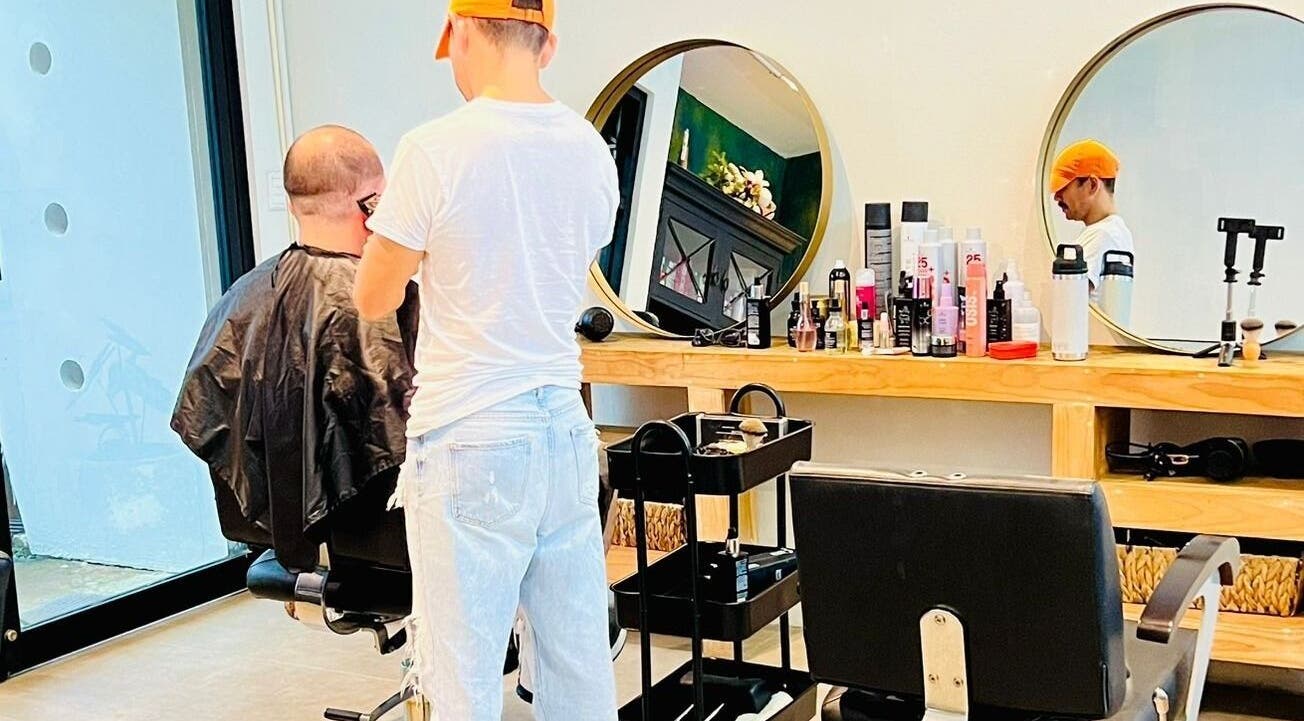 Un estilista corta el pelo de un cliente en Rivalbo, Grecia, Provincia De Alajuela, CR.