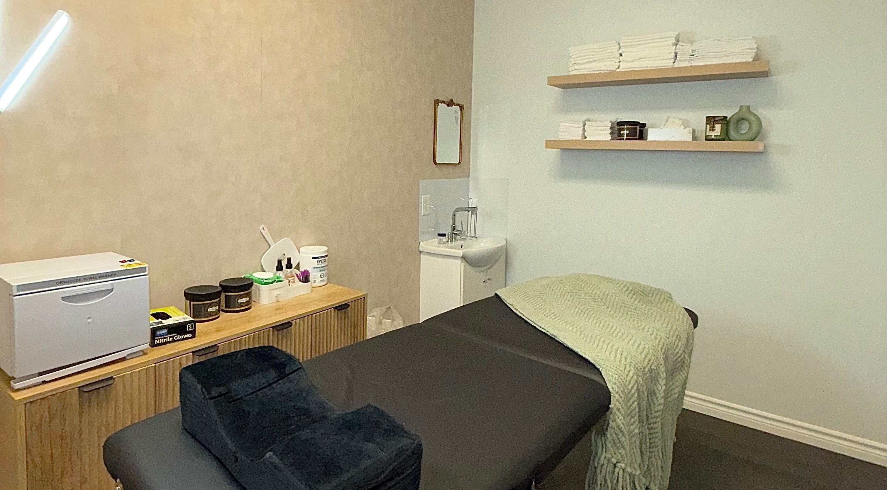 Treatment room at Skin Glow Studio x Sugar & Skin, London, Ontario, CA featuring a massage table and elegant decor.