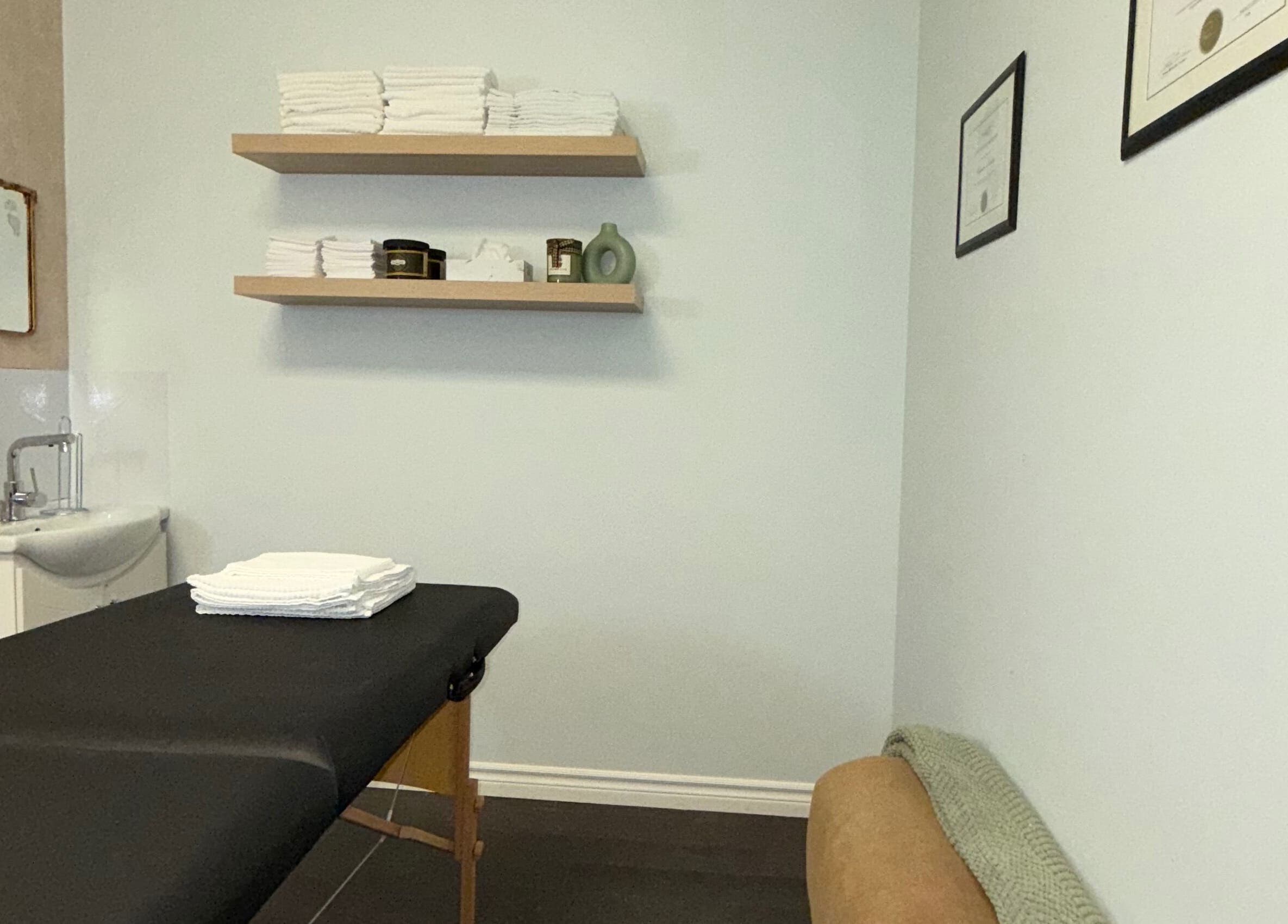 Elegant treatment room at Skin Glow Studio x Sugar & Skin in London, Ontario, CA with massage table and shelves.