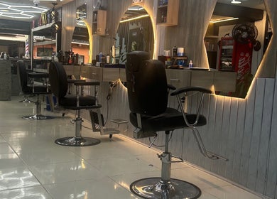Stylish interior of American Barber Shop in Marinilla, Antioquia, CO with sleek chairs and illuminated mirrors.