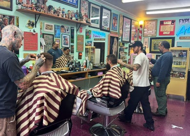 Dans Traditional Barbershop in Auckland, Auckland, NZ with barbers styling clients in a vintage setting.
