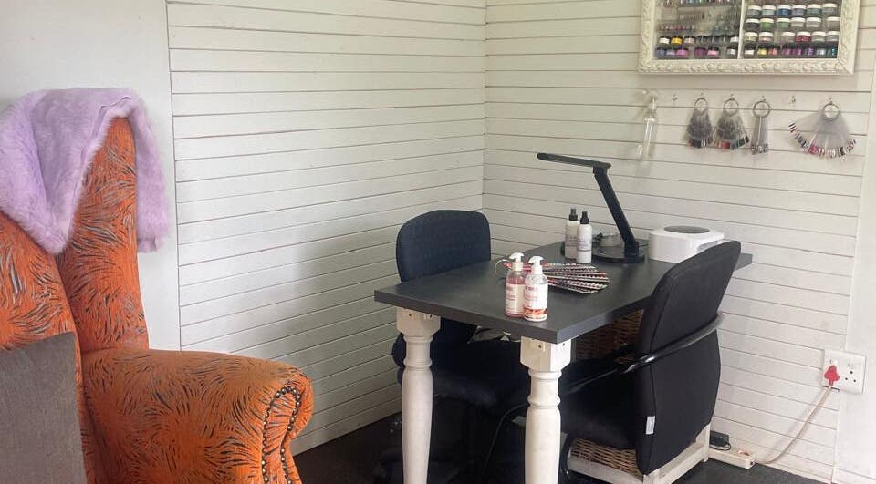 Cozy manicure station at SassyNails, Pretoria, Gauteng, ZA with plush seating and nail polish display.