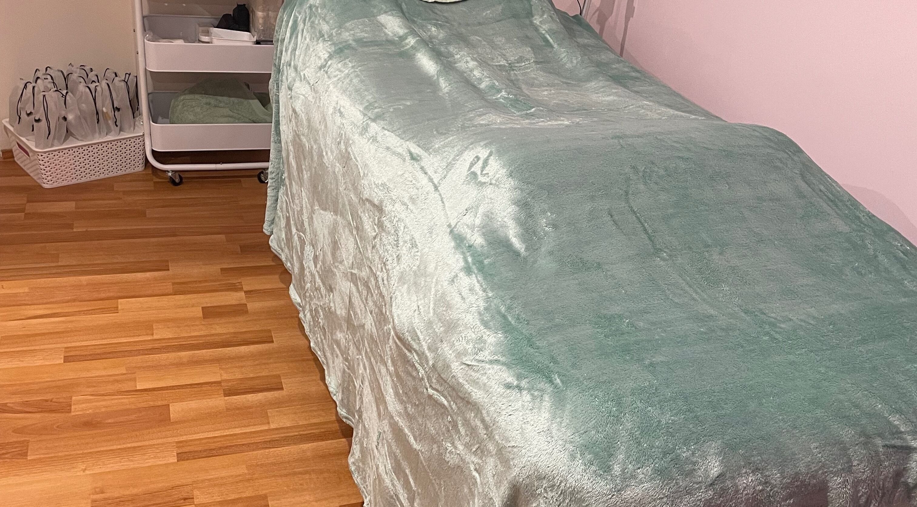 Cozy treatment room at EverBloom Studio, Sinagra, Western Australia, AU, with a soft mint green bed.