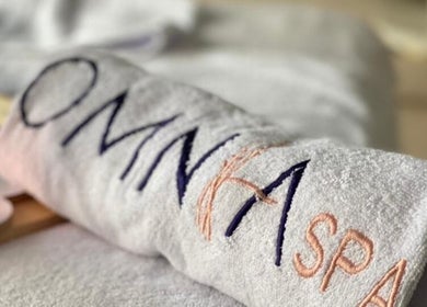 منشفة مع شعار Omnia Spa Home Service | Riyadh في الرياض، منطقة الرياض، السعودية.