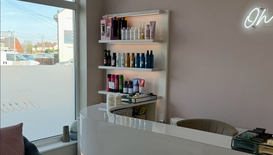 Reception at Sophia The Hairstylist, Ipswich, England, GB, displaying hair products on illuminated shelves.