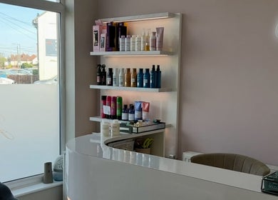 Reception at Sophia The Hairstylist, Ipswich, England, GB, displaying hair products on illuminated shelves.