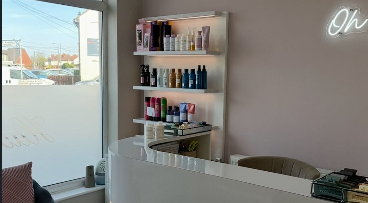 Reception at Sophia The Hairstylist, Ipswich, England, GB, displaying hair products on illuminated shelves.
