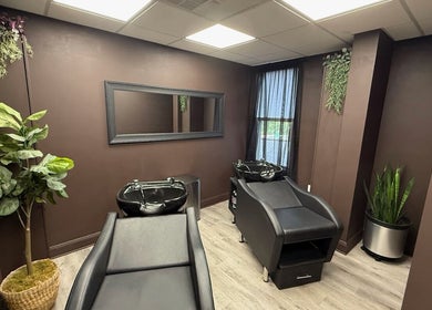 Elegant salon wash area at Brunetto Beauty, Oakland, New Jersey, US with sleek black chairs and lush plants.