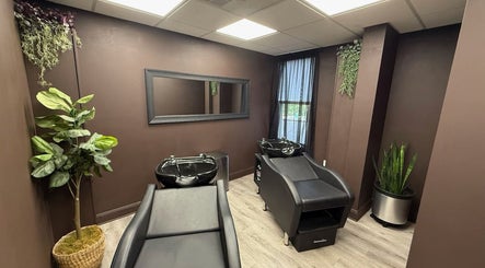 Elegant salon wash area at Brunetto Beauty, Oakland, New Jersey, US with sleek black chairs and lush plants.