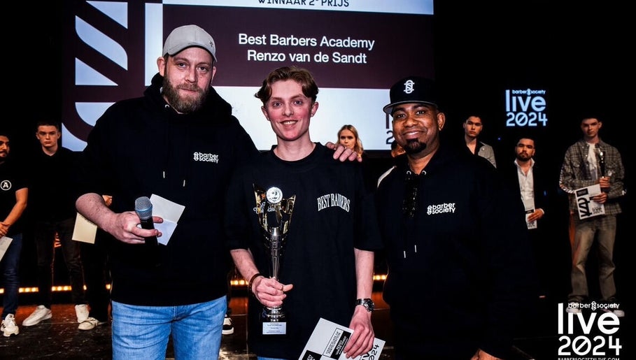 Kappersprijsuitreiking bij Men&Gents, Moergestel, Noord-brabant, NL met een trofee en gelukkige winnaars.