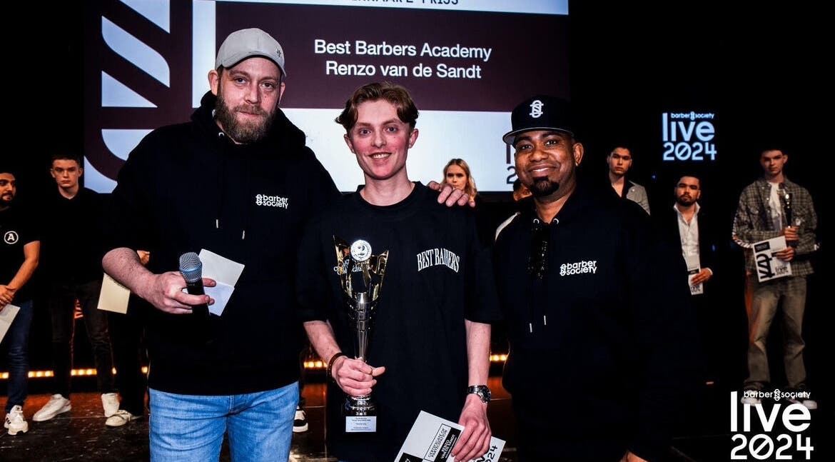 Winnaar ontvangt prijs bij Men&Gents in Moergestel, Noord-brabant, NL, op een podium met publiek.