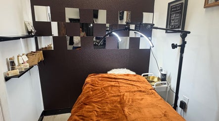 Cozy treatment room at Noire Naturels Aesthetics, Dallas, Texas, US with warm lighting and plush decor.