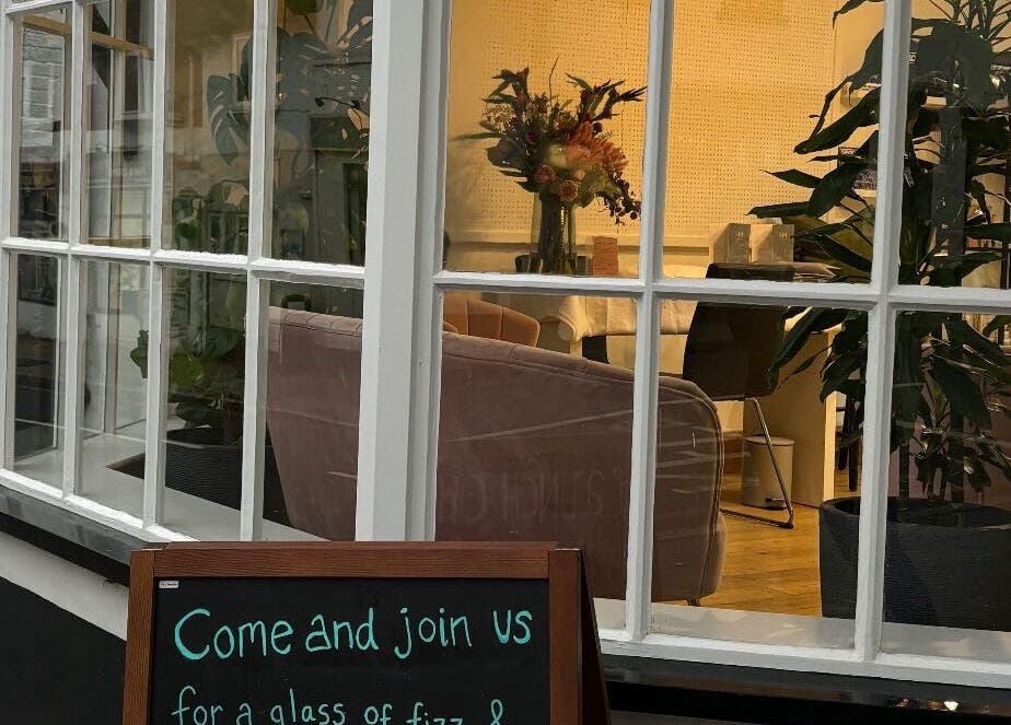 Inviting exterior of Glow Up With Molly, Wheathampstead, England. Cozy seating and plants create a welcoming vibe.