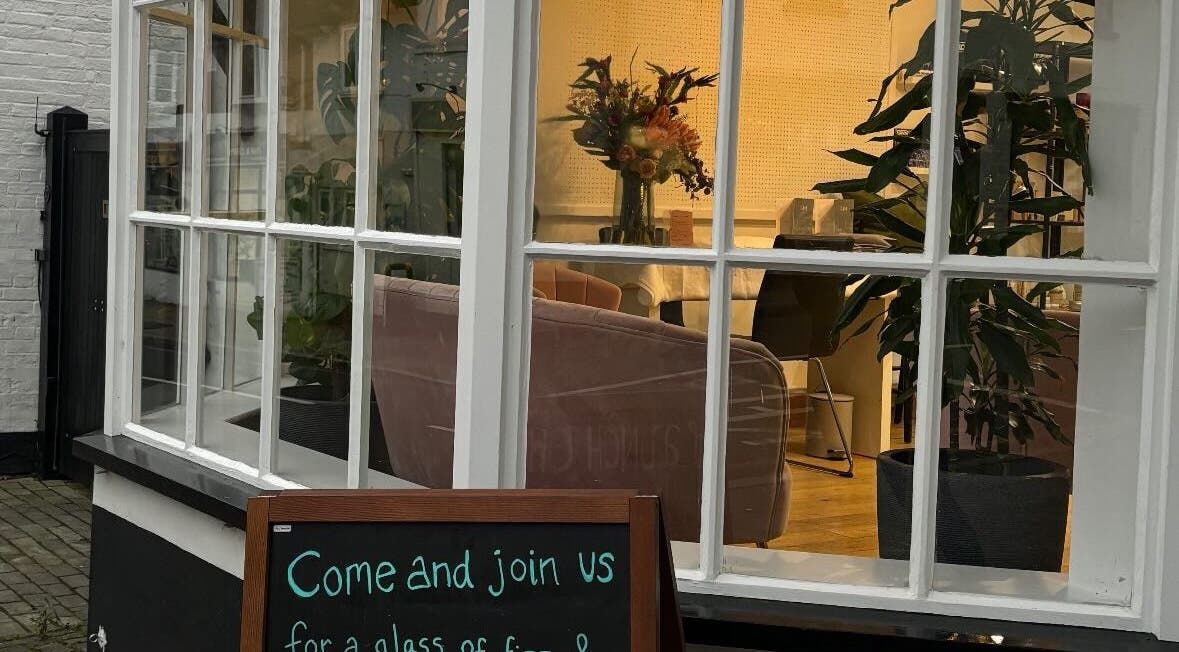 Inviting exterior of Glow Up With Molly, Wheathampstead, England. Cozy seating and plants create a welcoming vibe.