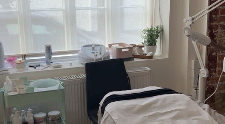 Cozy skincare room at Glow Up With Molly in Wheathampstead, England, GB, featuring treatment bed and skincare products.