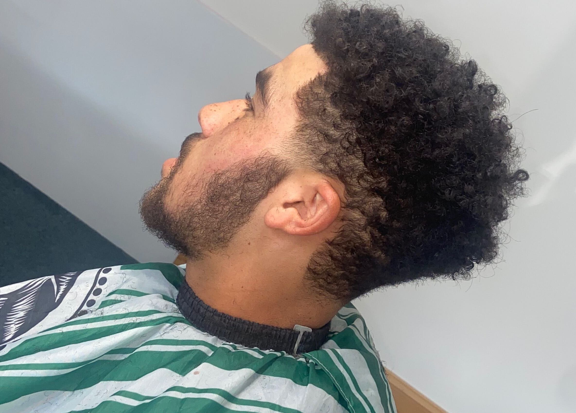 Fresh haircut at crainerscutz in Ramsey, Ramsey, IM featuring well-styled curls and groomed beard.