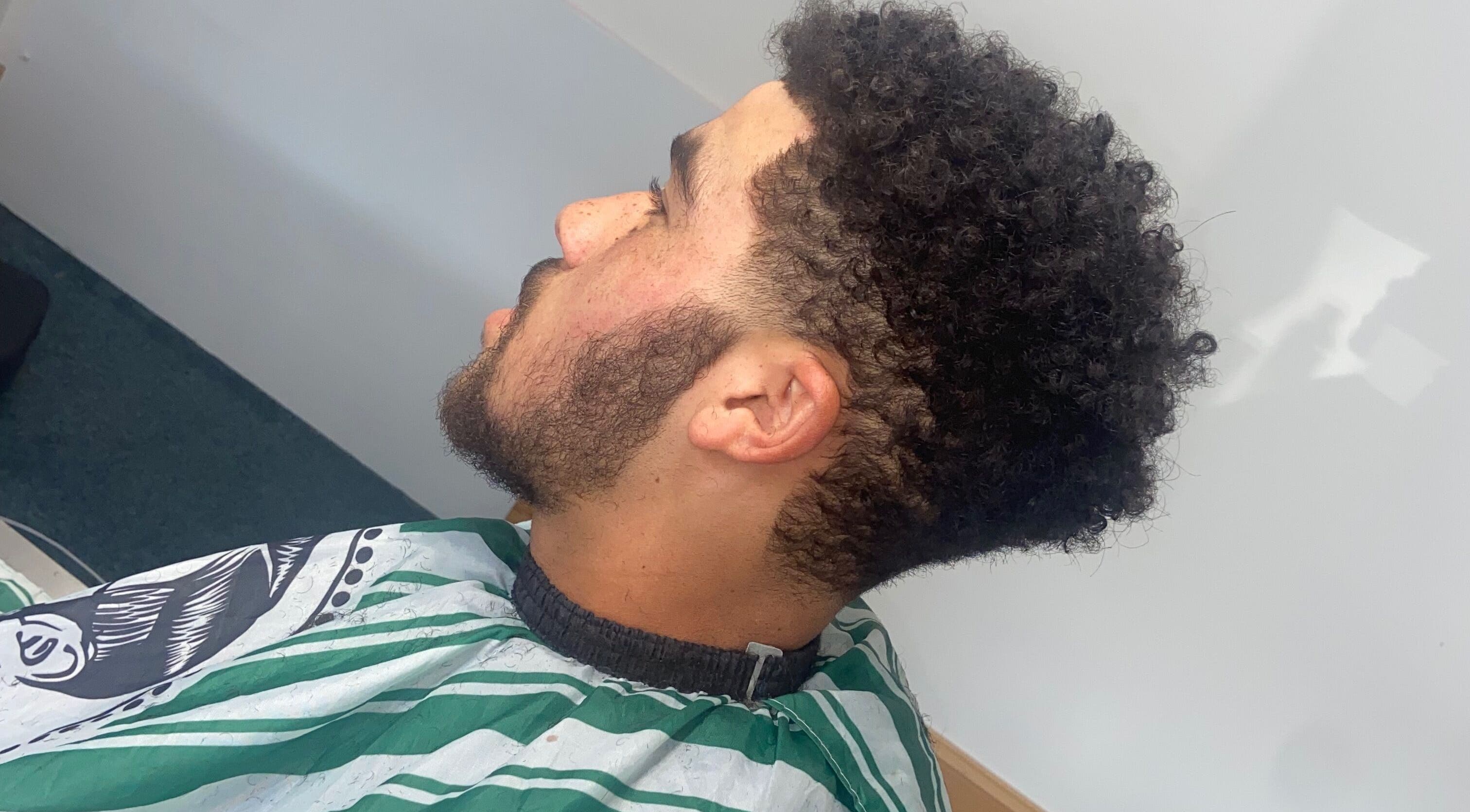 Fresh haircut at crainerscutz in Ramsey, Ramsey, IM featuring well-styled curls and groomed beard.