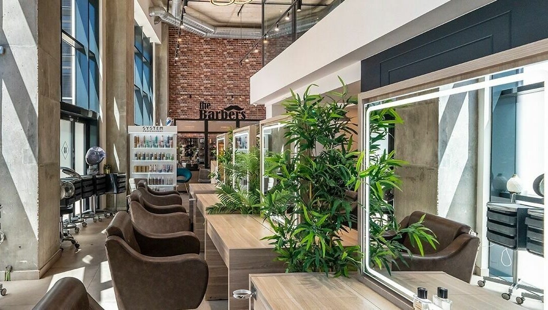 Modern interior of Studio 44 On Madison in Gibraltar, GI featuring stylish barber chairs and lush greenery.