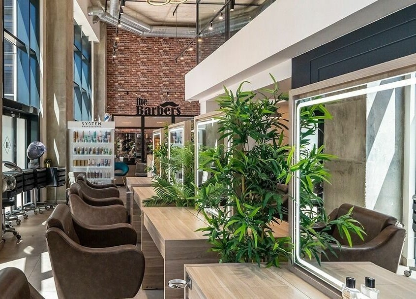 Modern interior of Studio 44 On Madison in Gibraltar, GI featuring stylish barber chairs and lush greenery.