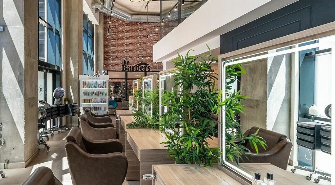 Modern interior of Studio 44 On Madison in Gibraltar, GI featuring stylish barber chairs and lush greenery.