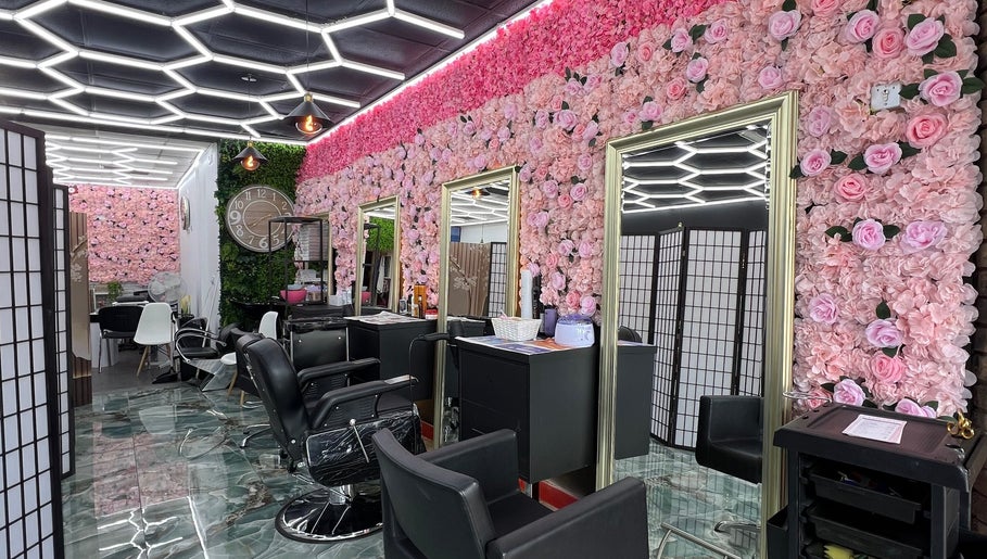 Interior of Lady’s Lux Beauty in Salford, England with floral walls and modern styling chairs.
