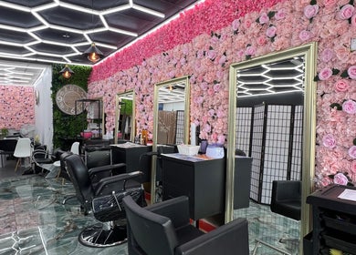 Interior of Lady’s Lux Beauty in Salford, England with floral walls and modern styling chairs.