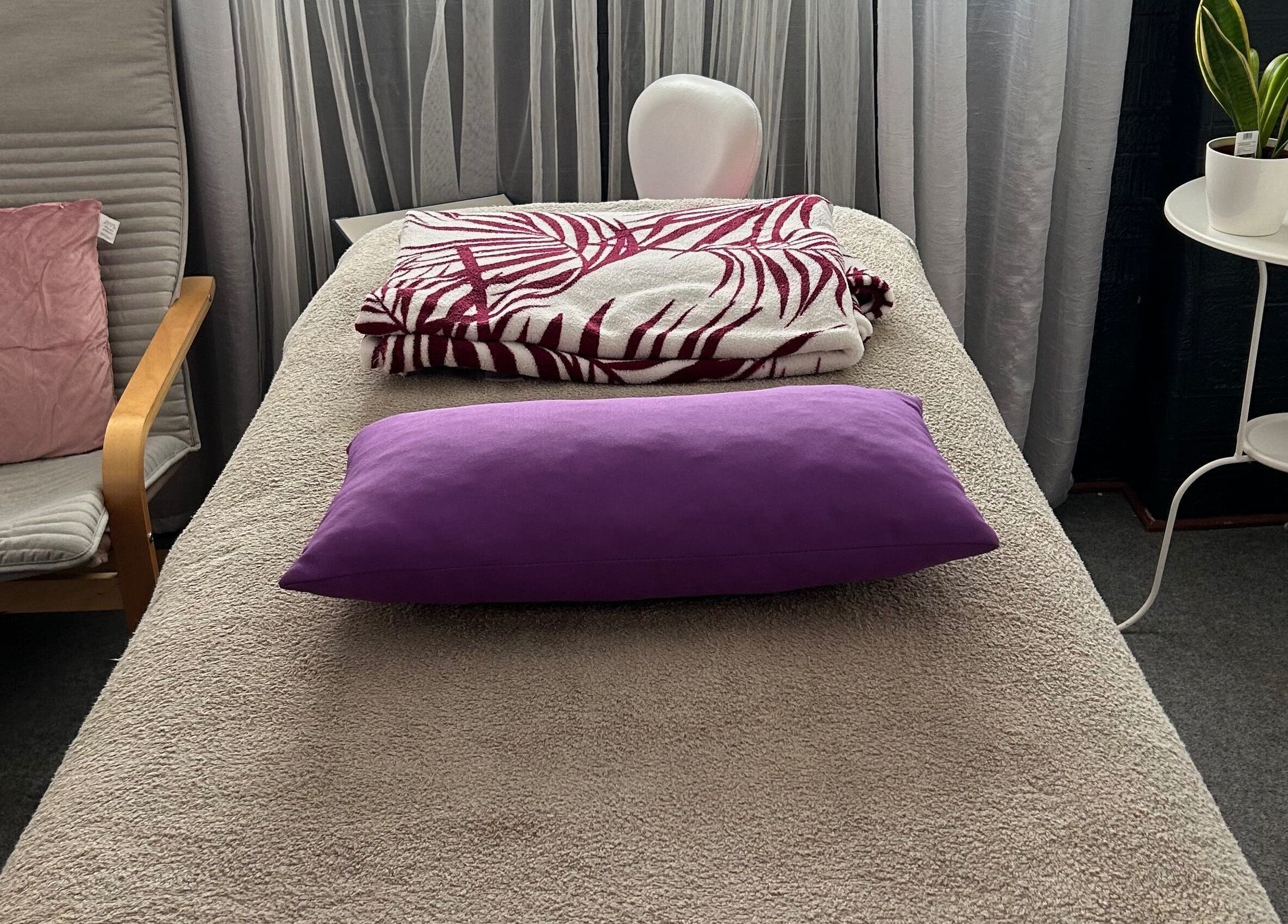 Sala de terapia em Tranquilamente Terapias, Agualva-Cacém, Lisboa, PT, com cama de massagem e almofada roxa.