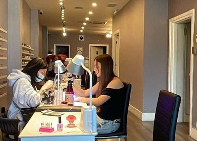 Customer enjoying a manicure at Westboro Infinity Nails in Ottawa, Ontario, CA, surrounded by polish options.