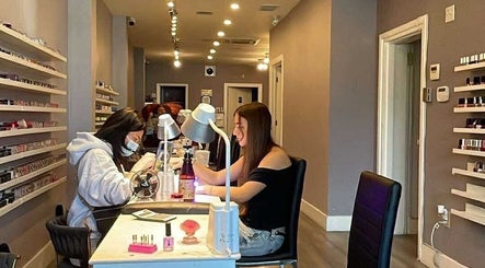 Customer enjoying a manicure at Westboro Infinity Nails in Ottawa, Ontario, CA, surrounded by polish options.