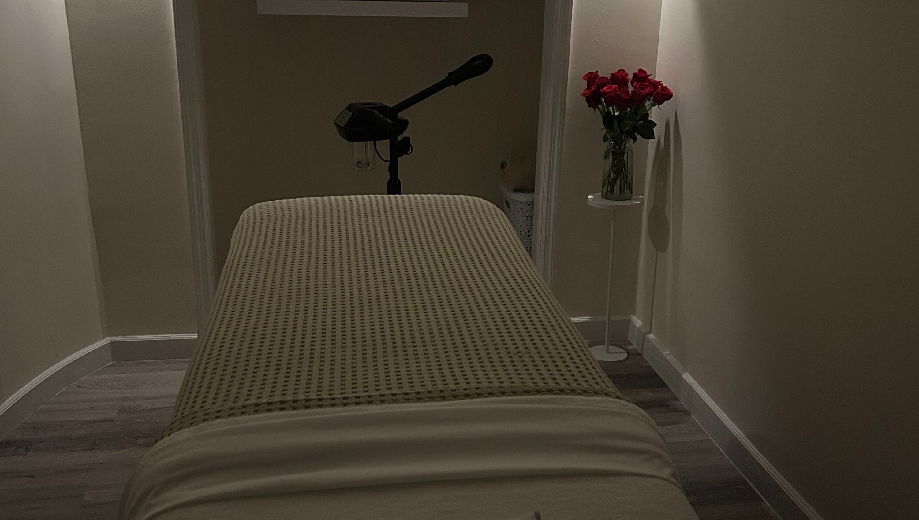 Peaceful treatment room at Skin Knead Beauty, Nassau, New Providence, BS with table and roses.