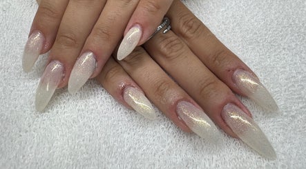 Elegant, glittery nail design at Golden Empire, Xgħajra, MT showcasing long, tapered tips.