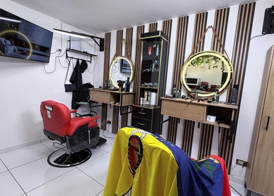 Interior moderno de MACCHIATO BARBERSTUDIO en Santiago De Surco, Provincia De Lima, PE, con sillón rojo icónico.