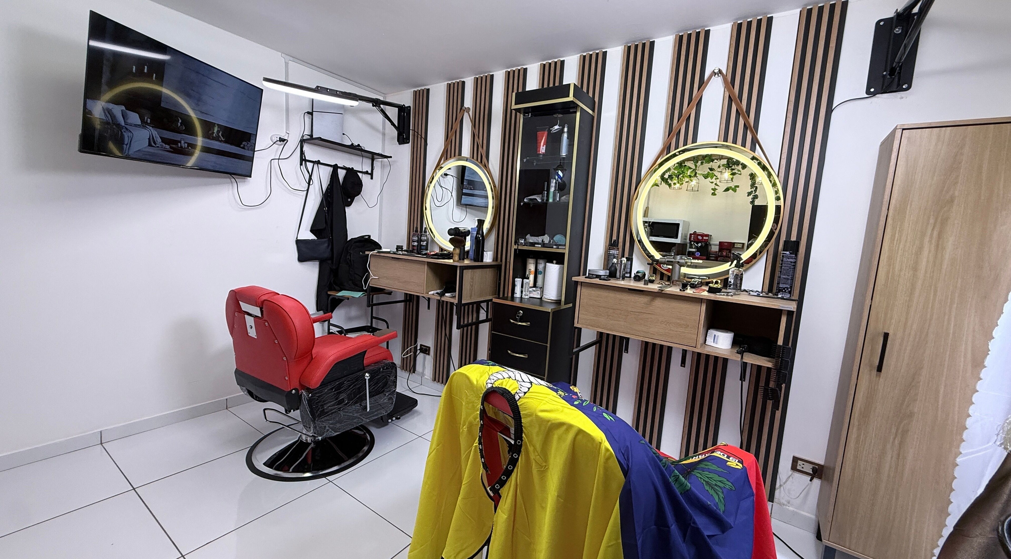 Interior moderno de MACCHIATO BARBERSTUDIO en Santiago De Surco, Provincia De Lima, PE, con sillón rojo icónico.