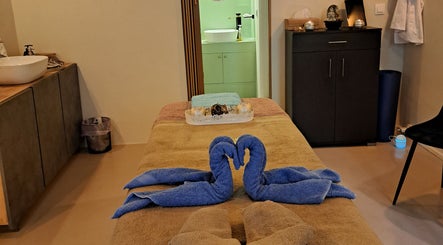 Δωμάτιο θεραπείας στο NIRVANA MASSAGE AND BEAUTY SPA, Χανιά, GR με πετσέτες σε σχήμα κύκνων.