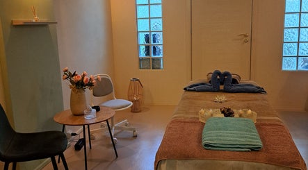 Εσωτερικό δωματίου χαλάρωσης στο NIRVANA MASSAGE AND BEAUTY SPA, Χανιά, GR με τραπέζι μασάζ και διακόσμηση.