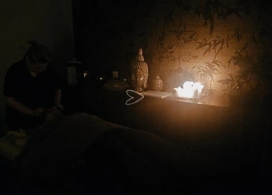 Ambiente relaxante no Essence Wellness & Massages, Vila Nova de Gaia, PT, com iluminação suave e buda decorativo.