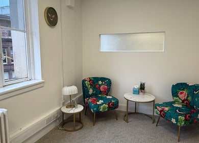 Inviting therapy room at The Feel Better Psychological Services, Glasgow, Scotland, GB. Features floral chairs and tables.