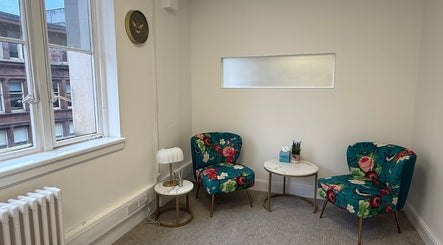 Inviting therapy room at The Feel Better Psychological Services, Glasgow, Scotland, GB. Features floral chairs and tables.