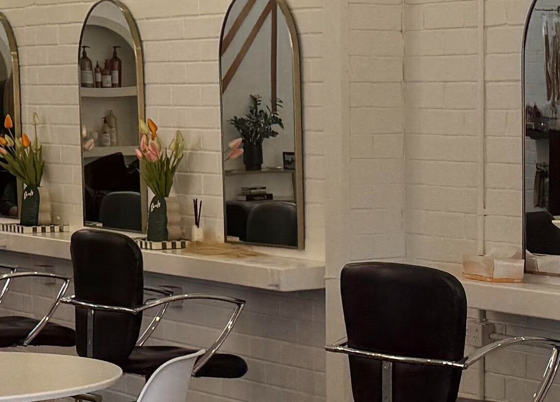 Sleek styling stations at NKD Hair Studio, Dianella, Western Australia, AU with modern mirrors and floral decor.