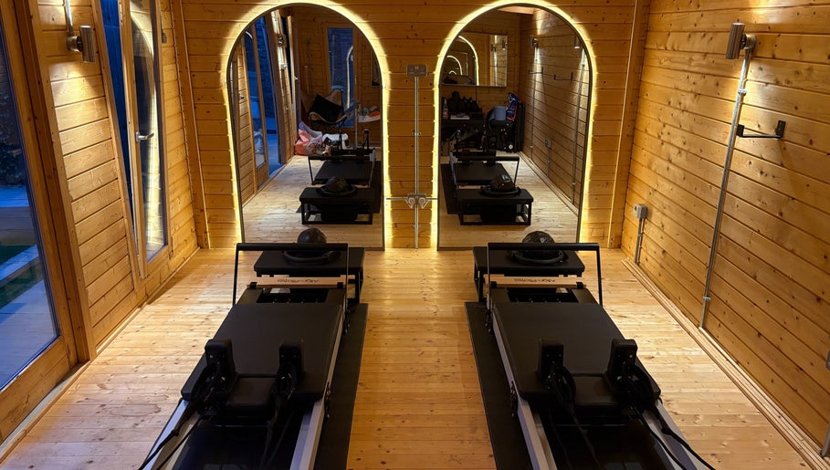 Pilates studio with reformers at The Reformama, Hoo, England, GB. Cozy wood-paneled design.
