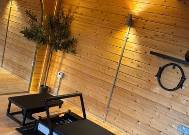 Sleek fitness area at The Reformama, Hoo, England, GB with Pilates equipment and wooden interior.