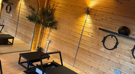 Sleek fitness area at The Reformama, Hoo, England, GB with Pilates equipment and wooden interior.