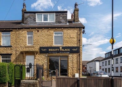 Beautiful stone building exterior of The Hairdeck, Pudsey, England, GB, under a clear blue sky.