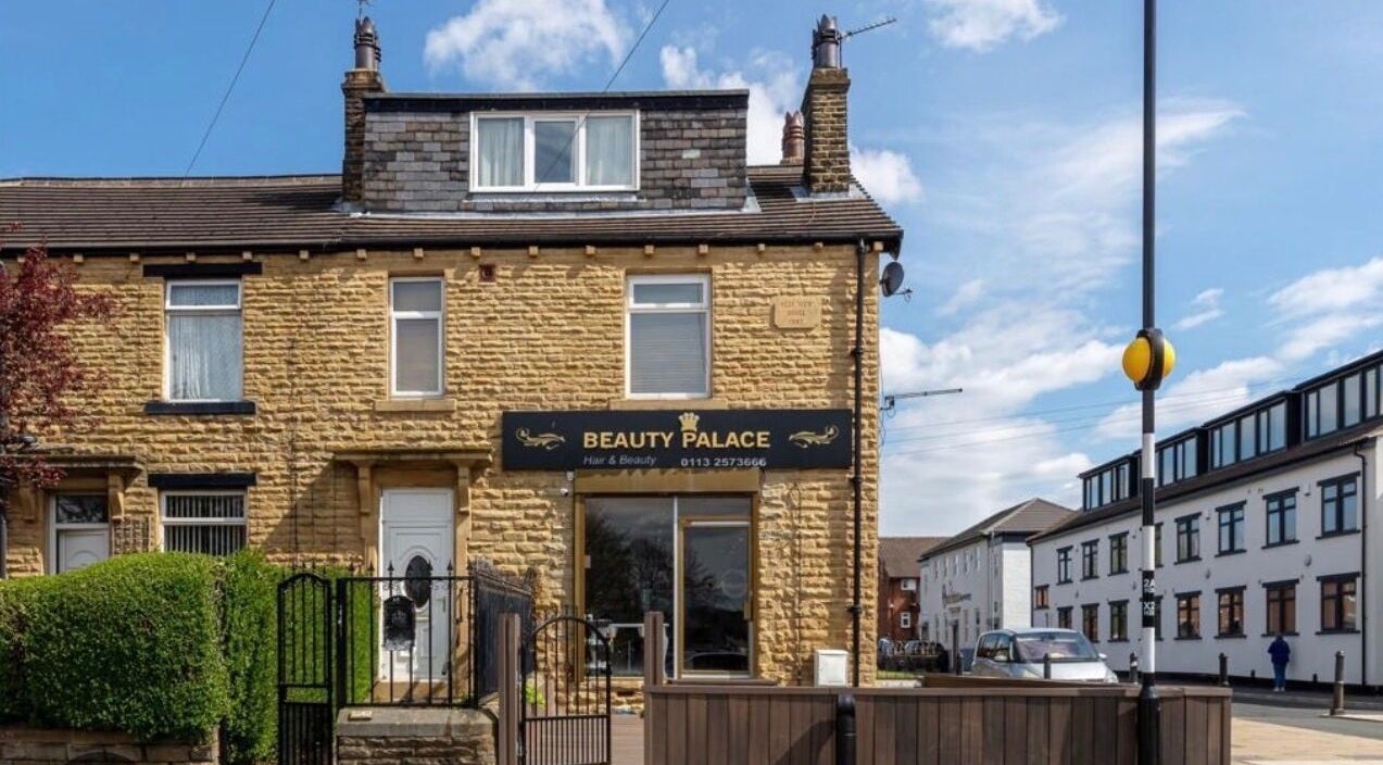 Beautiful stone building exterior of The Hairdeck, Pudsey, England, GB, under a clear blue sky.