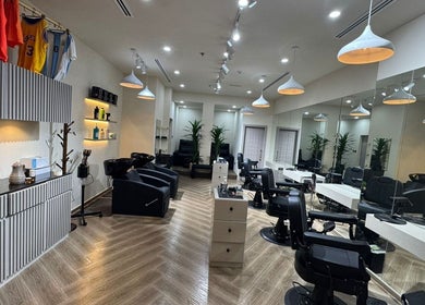 Modern interior of SGC Barbershop, Dubai, AE showcasing sleek chairs, mirrors, and ambient lighting.