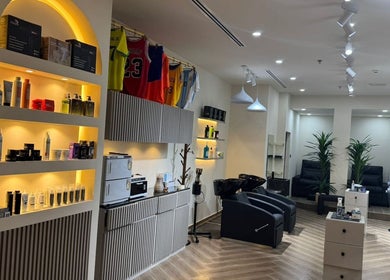 SGC Barbershop in Dubai, Dubai, AE featuring modern styling chairs and illuminated product shelves.