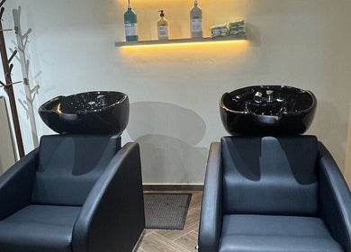 Luxury hair wash area at SGC Barbershop in Dubai, Dubai, AE, featuring sleek black chairs and basins.