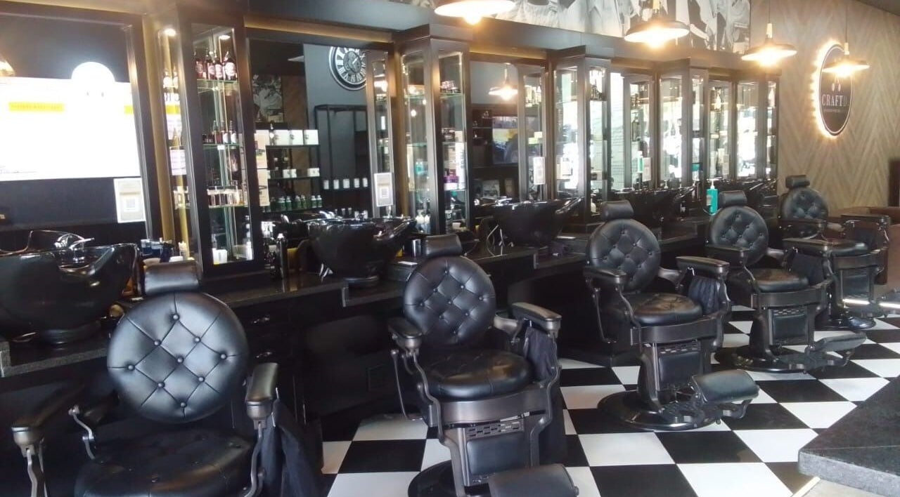 Elegant barbershop interior at CraftD Studios, Randburg, Gauteng, ZA, featuring stylish black chairs and mirrors.