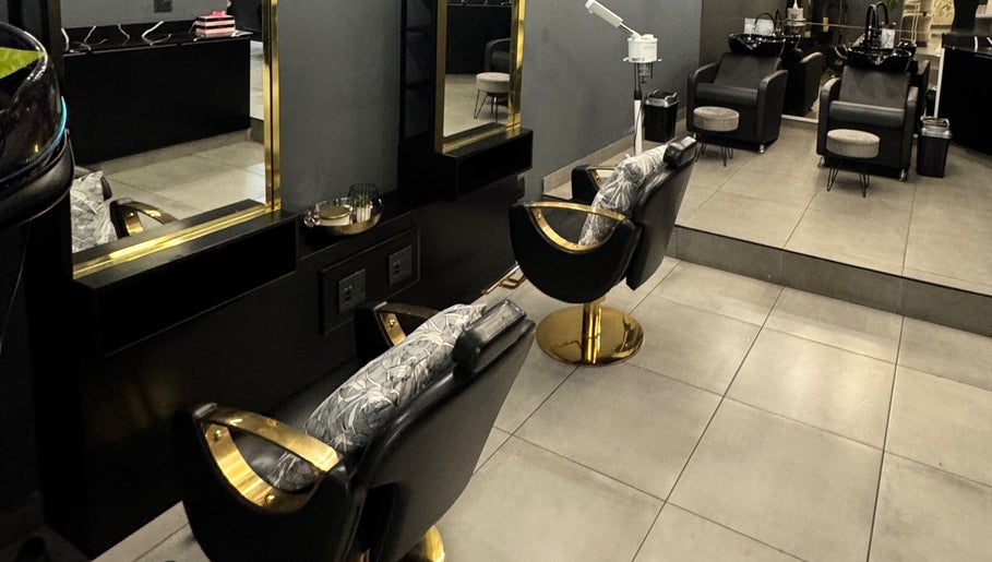 Elegant salon interior at THE BEAUTY BAR GROUP, Durban, Kwazulu-natal, ZA featuring chic black and gold chairs.